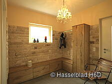 Diele mit Natursteinwand, Garderobenschrank und Sitztruhen aus Massivholz